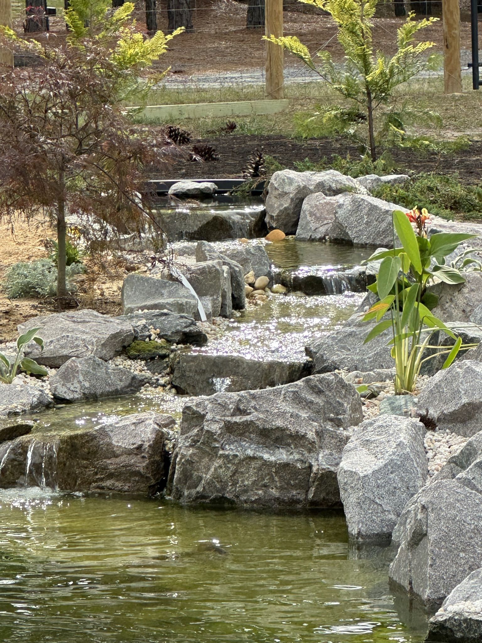 Rock waterfall flowing into a garden pond